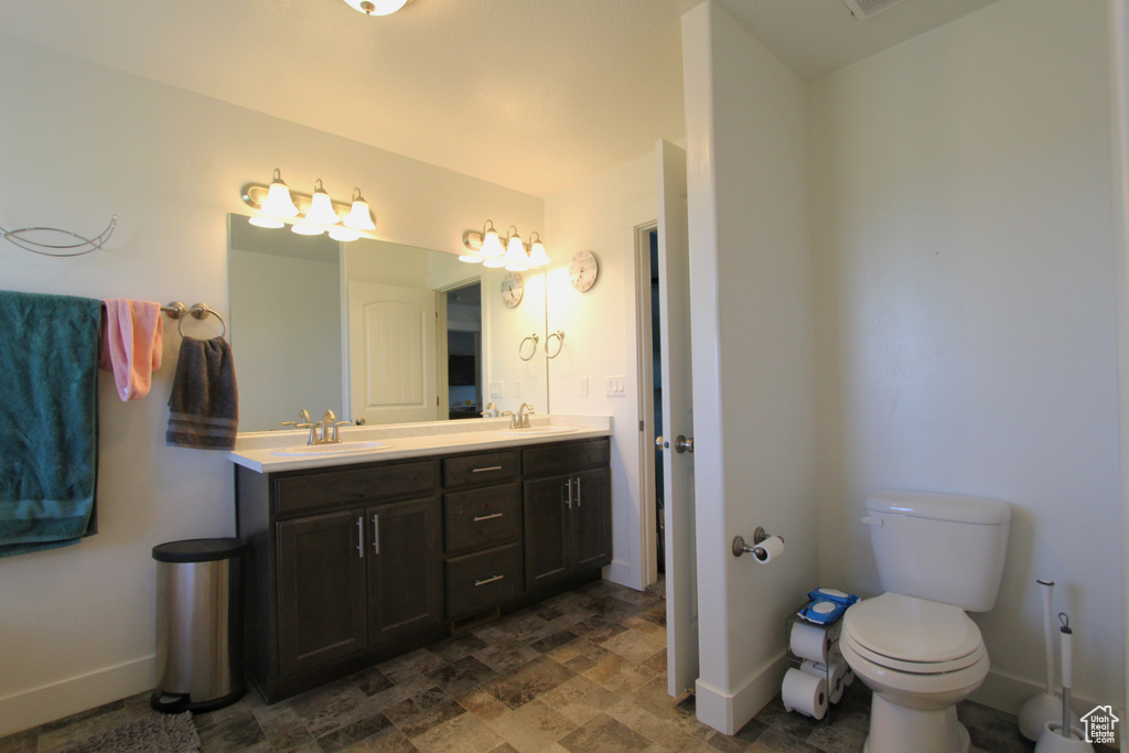 Bathroom with double vanity and stone finish floors