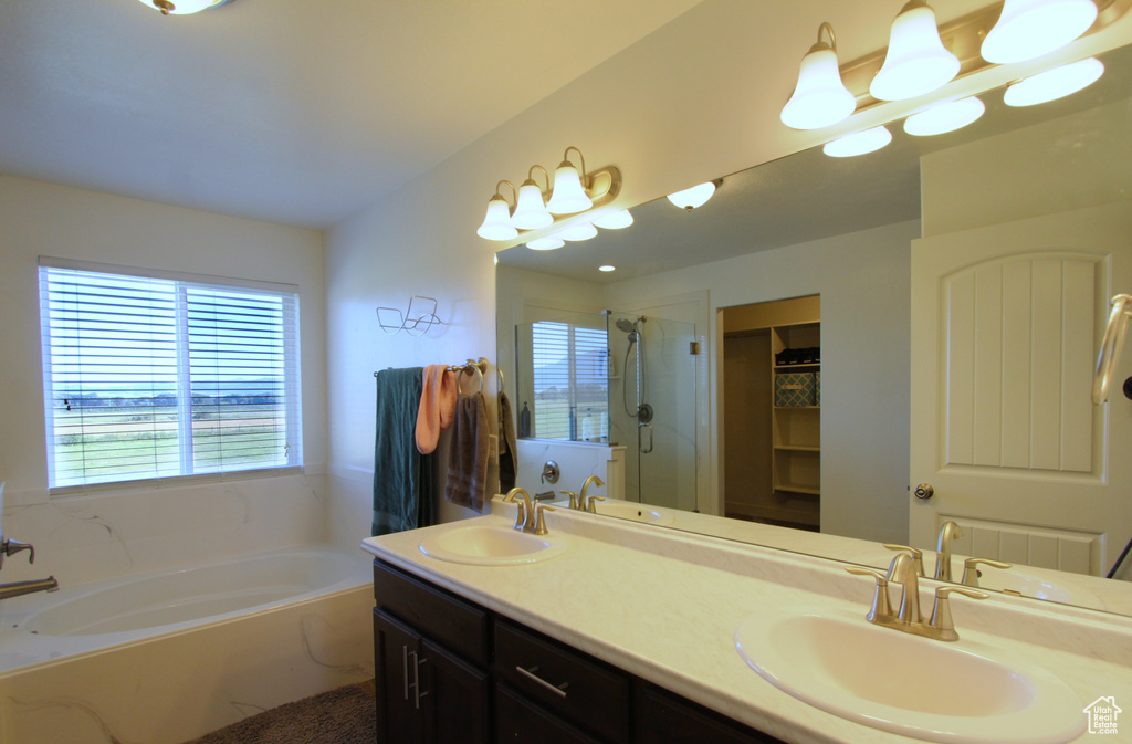 Full bath featuring a garden tub, a shower stall, double vanity, and a spacious closet