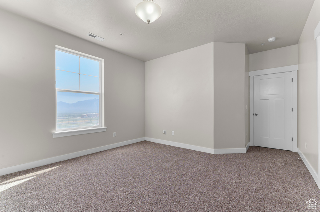 Unfurnished room featuring carpet and baseboards