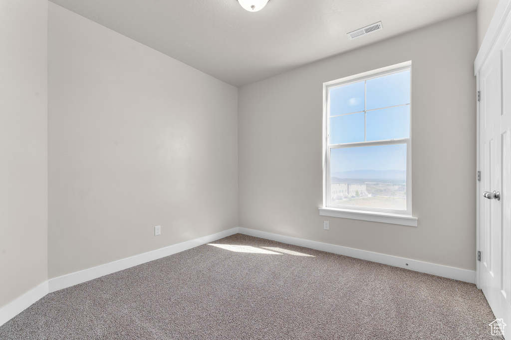 Carpeted empty room featuring plenty of natural light