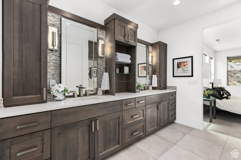 Ensuite bathroom featuring double vanity, tile patterned floors, and recessed lighting