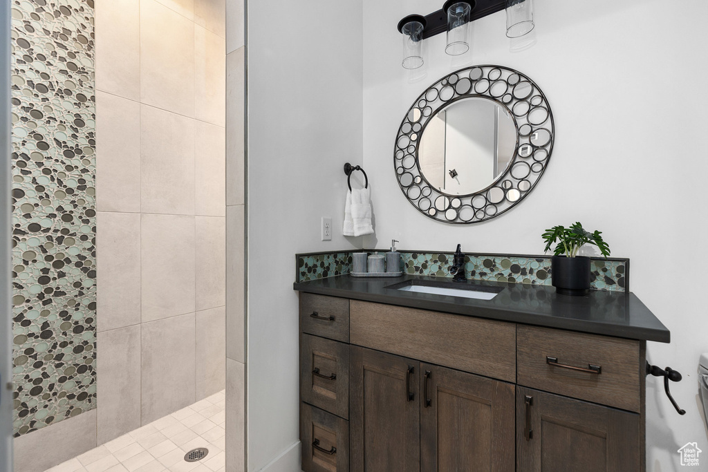 Bathroom featuring vanity and tiled shower