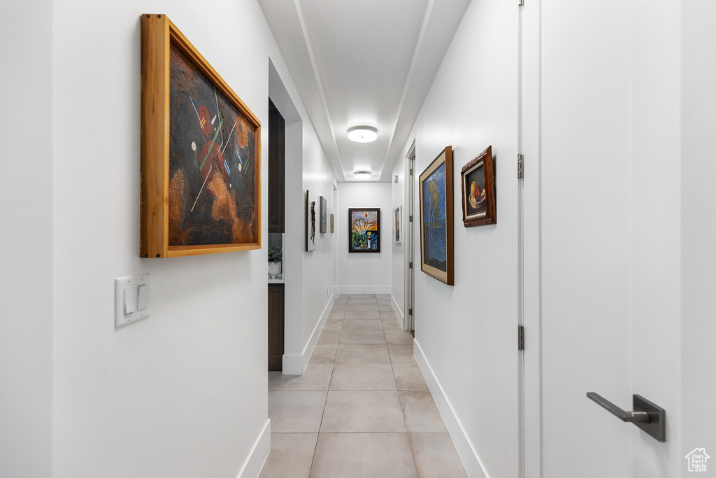 Corridor with light tile patterned floors and baseboards