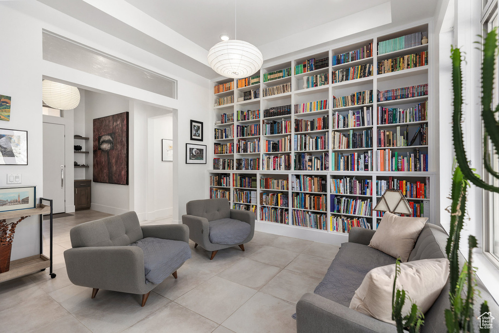 Living area featuring bookshelves, tile patterned flooring, and built in features