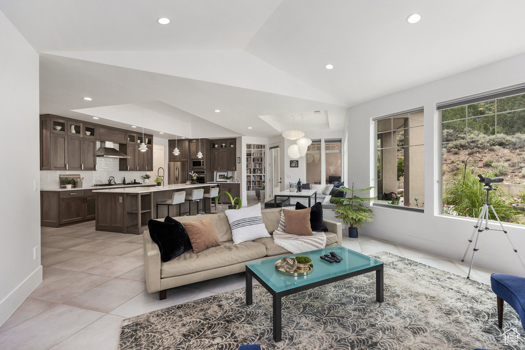 Living room featuring lofted ceiling, recessed lighting, and light tile patterned flooring