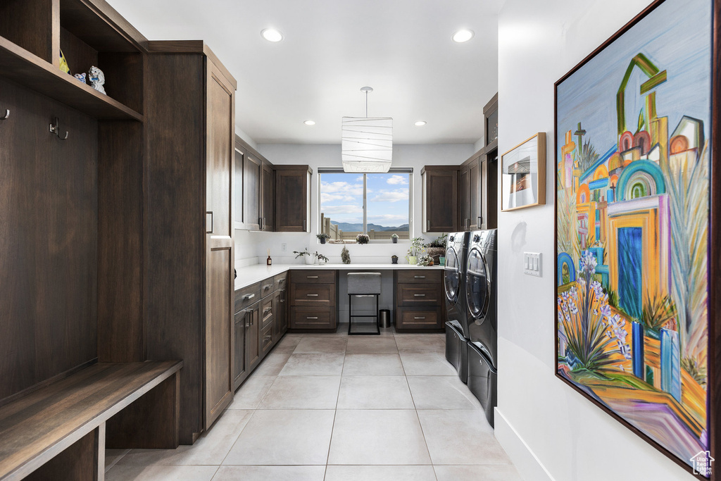 Kitchen with independent washer and dryer, dark brown cabinetry, light tile patterned floors, open shelves, and light countertops