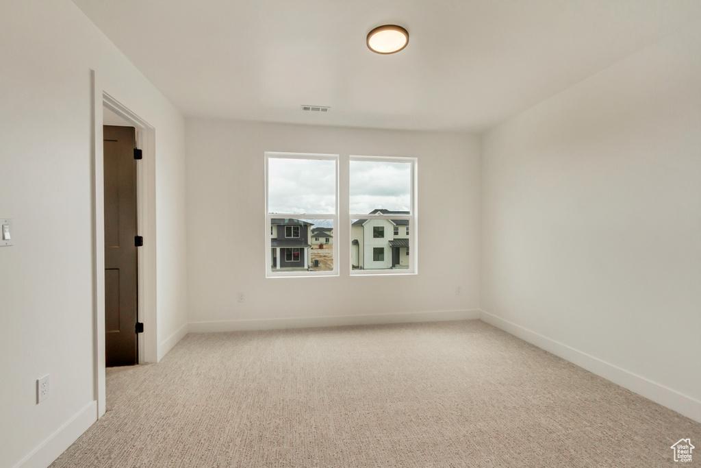 Empty room featuring carpet and baseboards