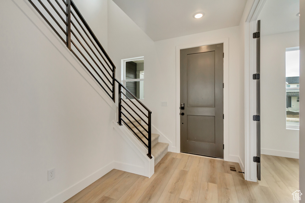 Foyer with light wood-style flooring, stairs, and recessed lighting