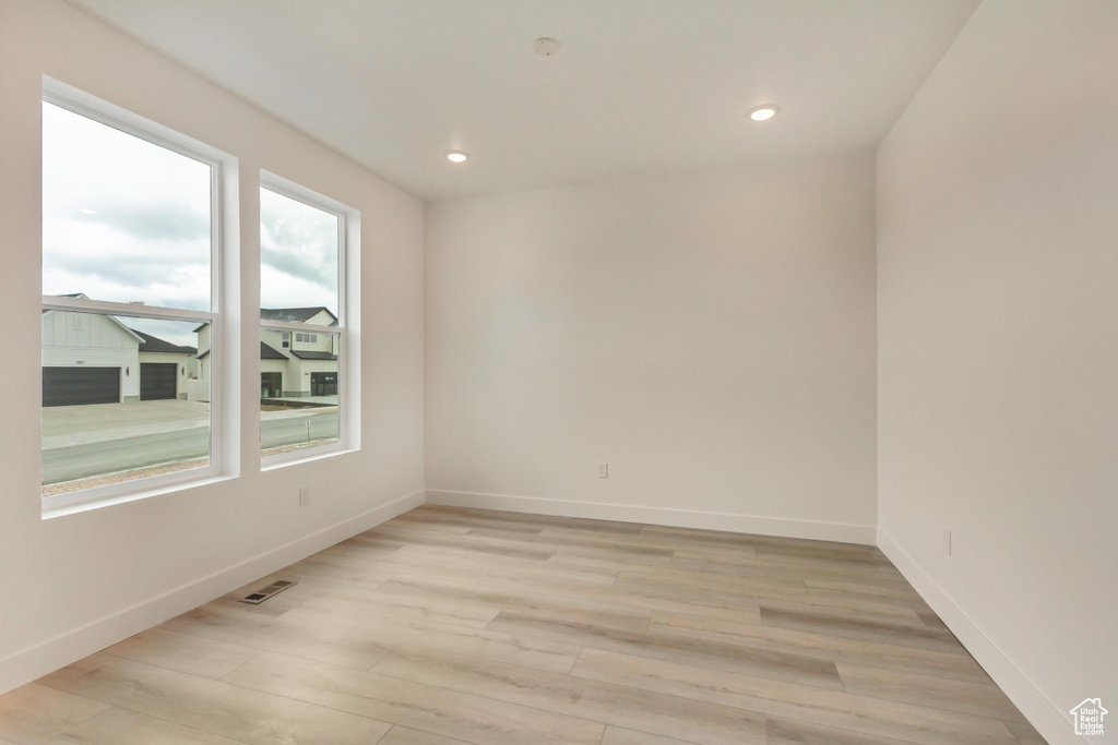 Empty room featuring light wood-type flooring and recessed lighting