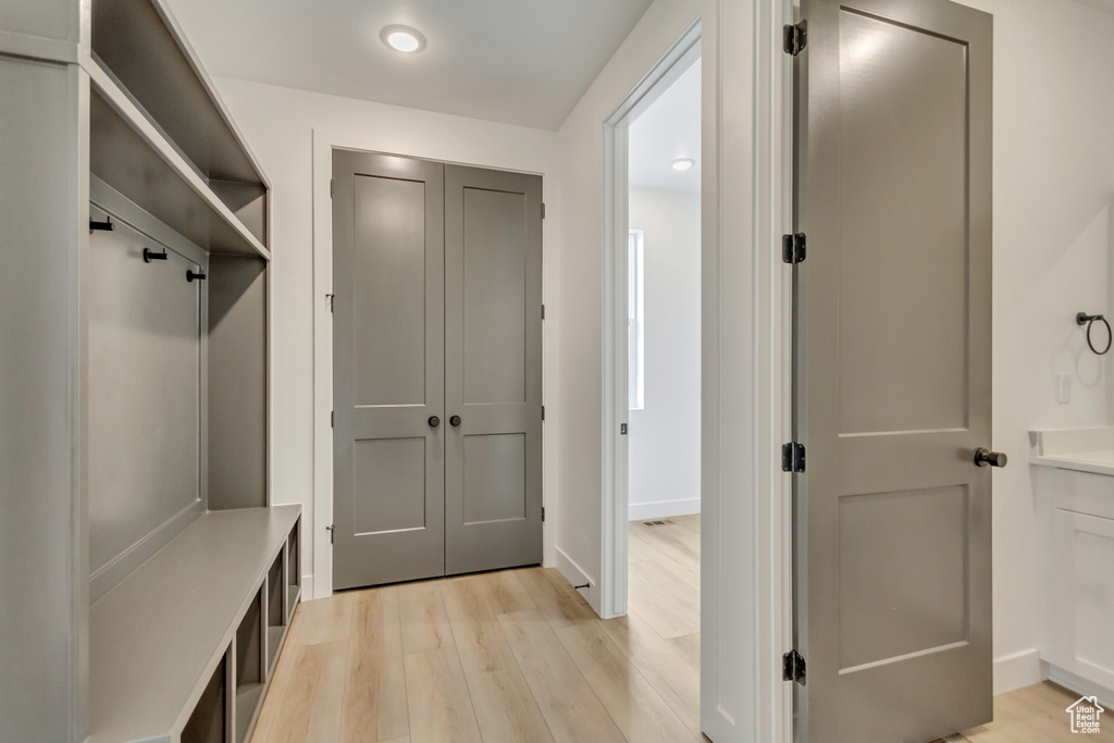 Mudroom with light wood finished floors and recessed lighting