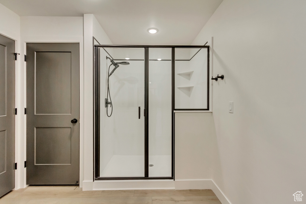 Full bath with a shower stall and wood finished floors