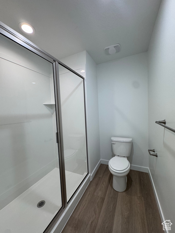 Bathroom featuring wood finished floors and a stall shower