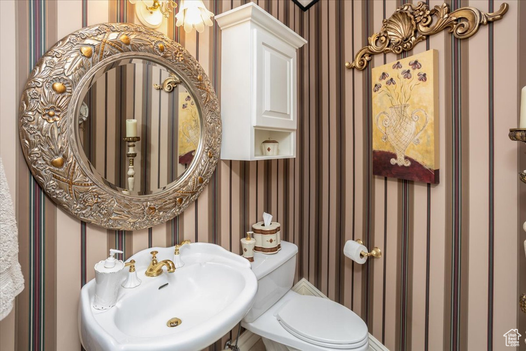 Half bathroom with wallpapered walls and a sink