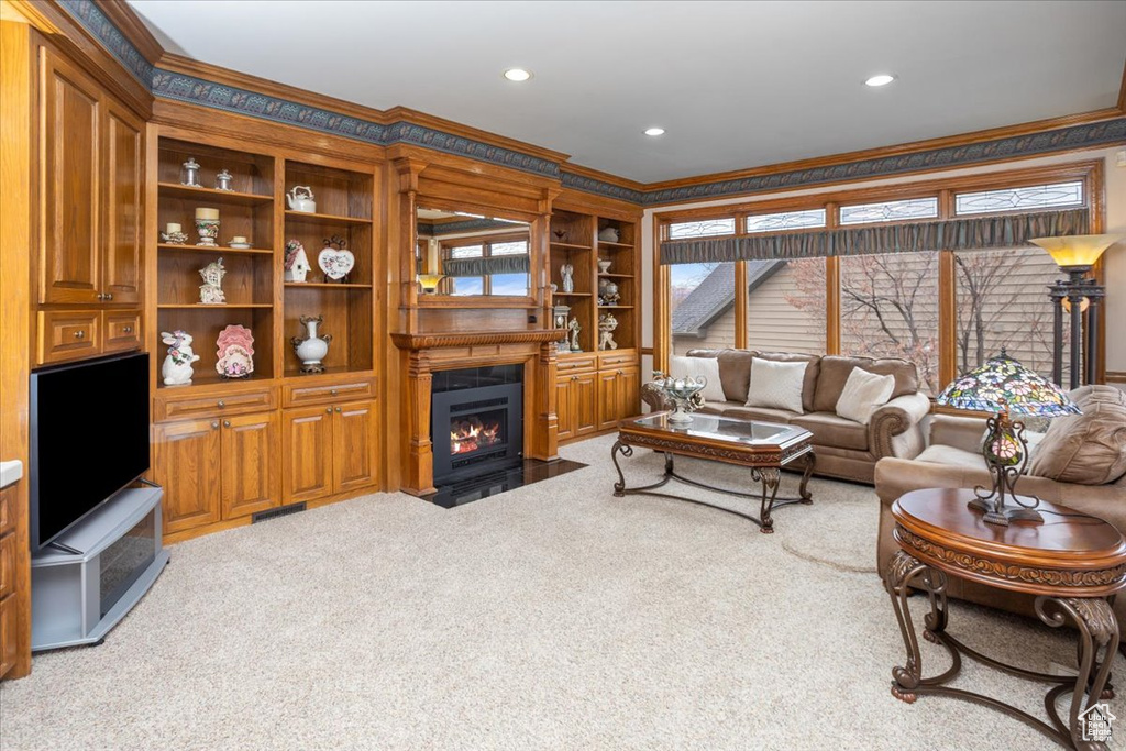 Living area with crown molding, carpet, a fireplace with flush hearth, and recessed lighting
