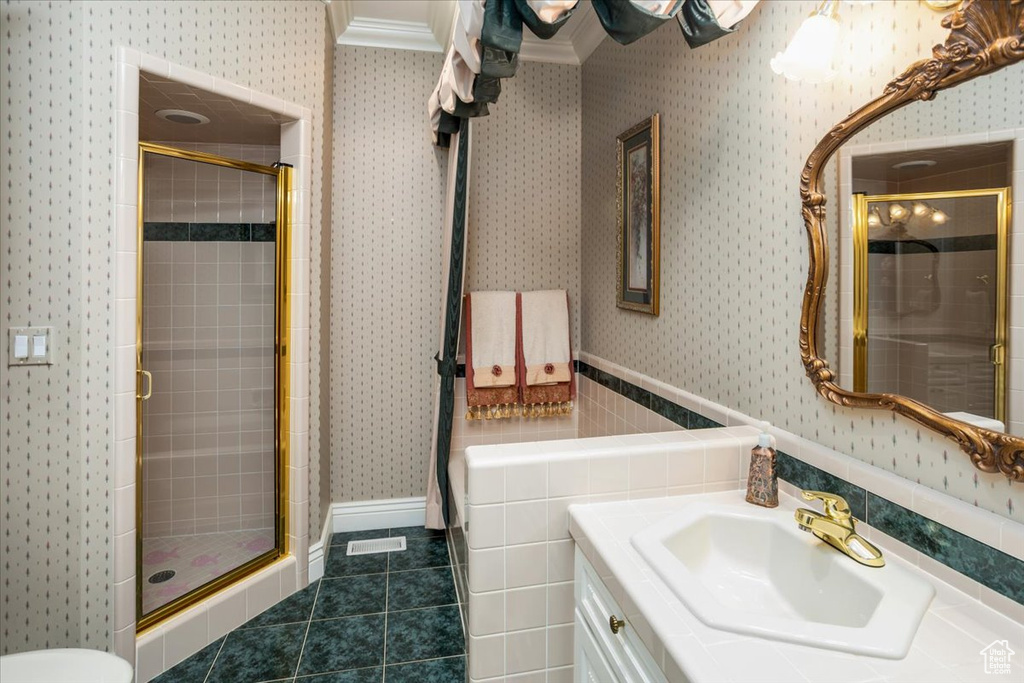 Full bath featuring wallpapered walls, a stall shower, vanity, tile patterned flooring, and crown molding