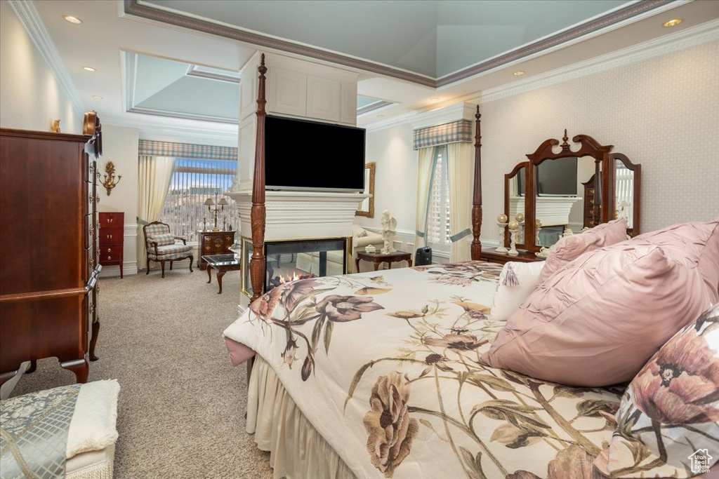 Bedroom featuring ornamental molding, light carpet, a multi sided fireplace, and a tray ceiling