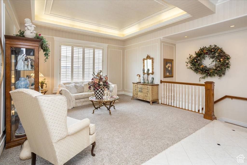 Tiled living area featuring a tray ceiling and ornamental molding