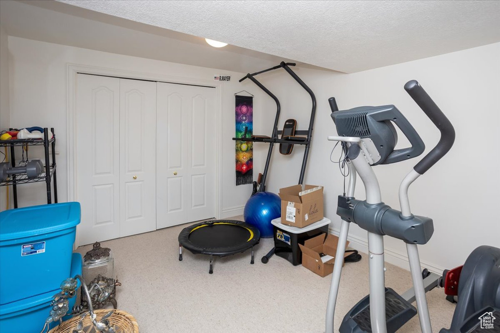 Workout area with carpet floors and a textured ceiling