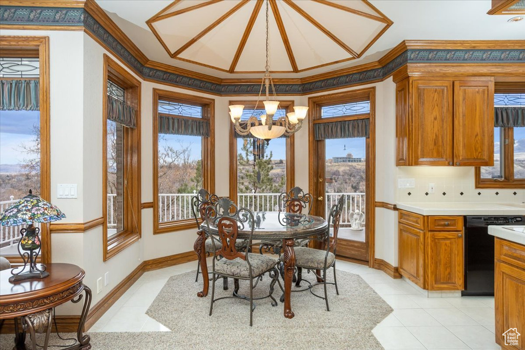 Dining space featuring a chandelier, crown molding, light tile patterned flooring, and plenty of natural light