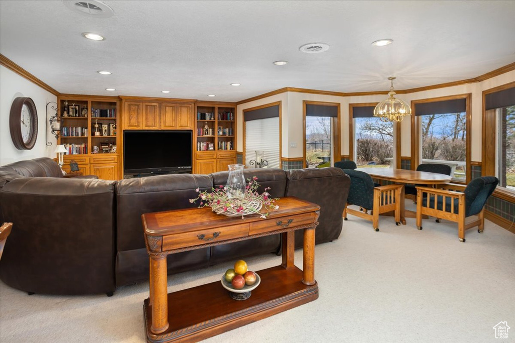 Living area featuring a chandelier, light carpet, ornamental molding, and recessed lighting