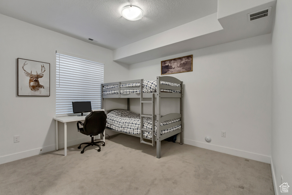 Bedroom with carpet floors and an office area