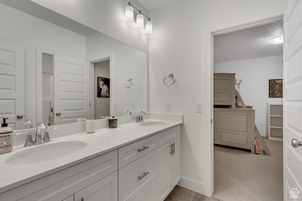 Full bathroom featuring double vanity and baseboards