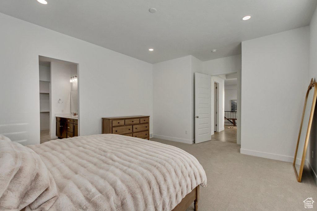 Bedroom featuring light carpet, recessed lighting, and connected bathroom