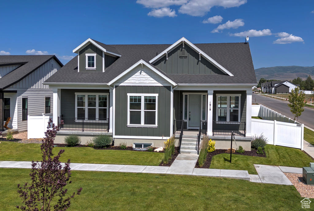 View of front of property featuring covered porch, roof with shingles, board and batten siding, and a mountain view