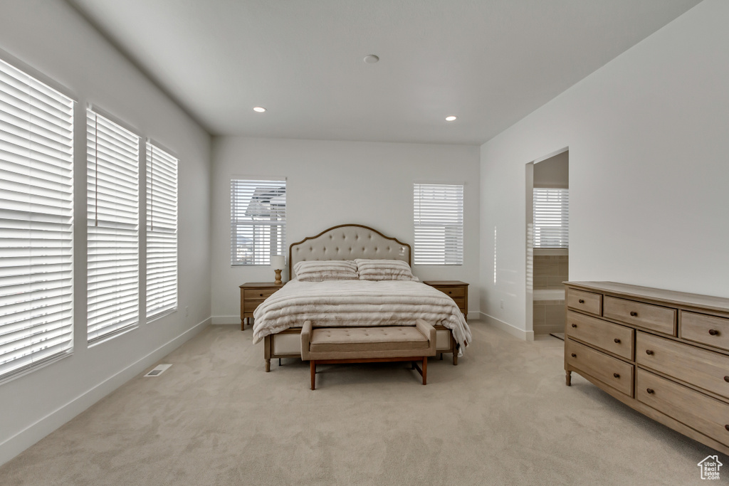 Bedroom featuring multiple windows, light colored carpet, and recessed lighting