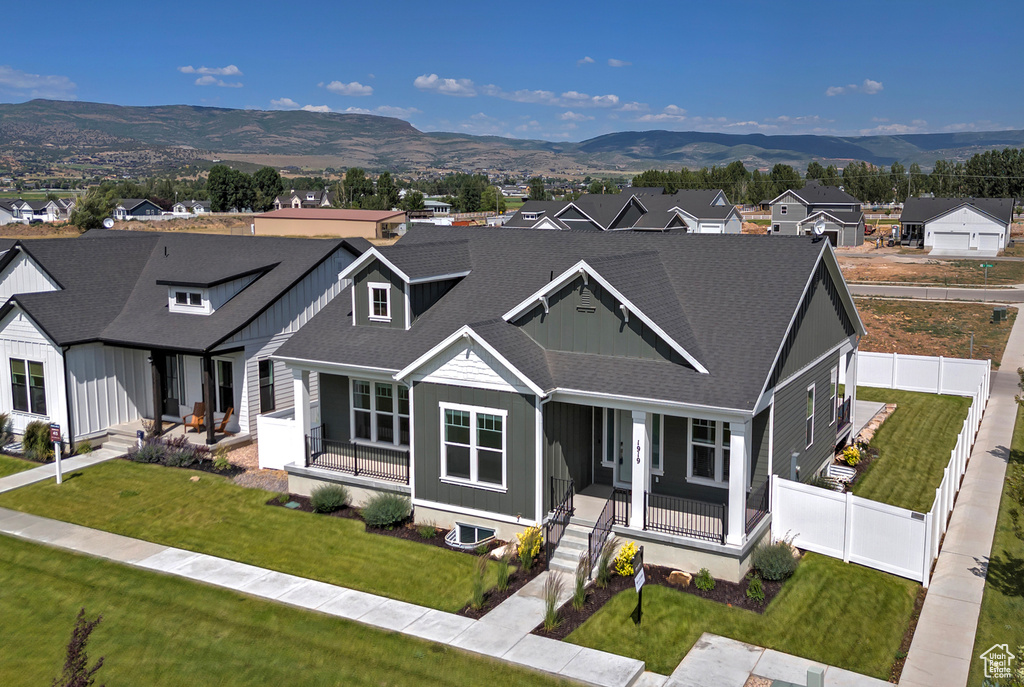 View of front of house with a porch, a mountain view, a shingled roof, a residential view, and board and batten siding