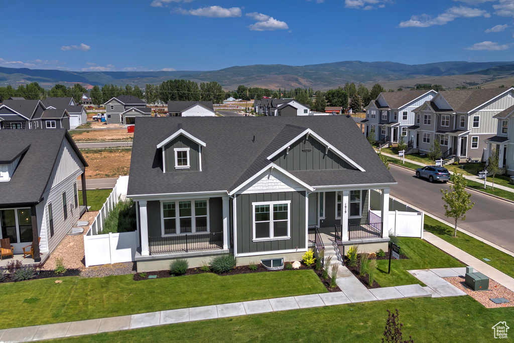 View of front facade featuring board and batten siding, a porch, a residential view, and a mountain view