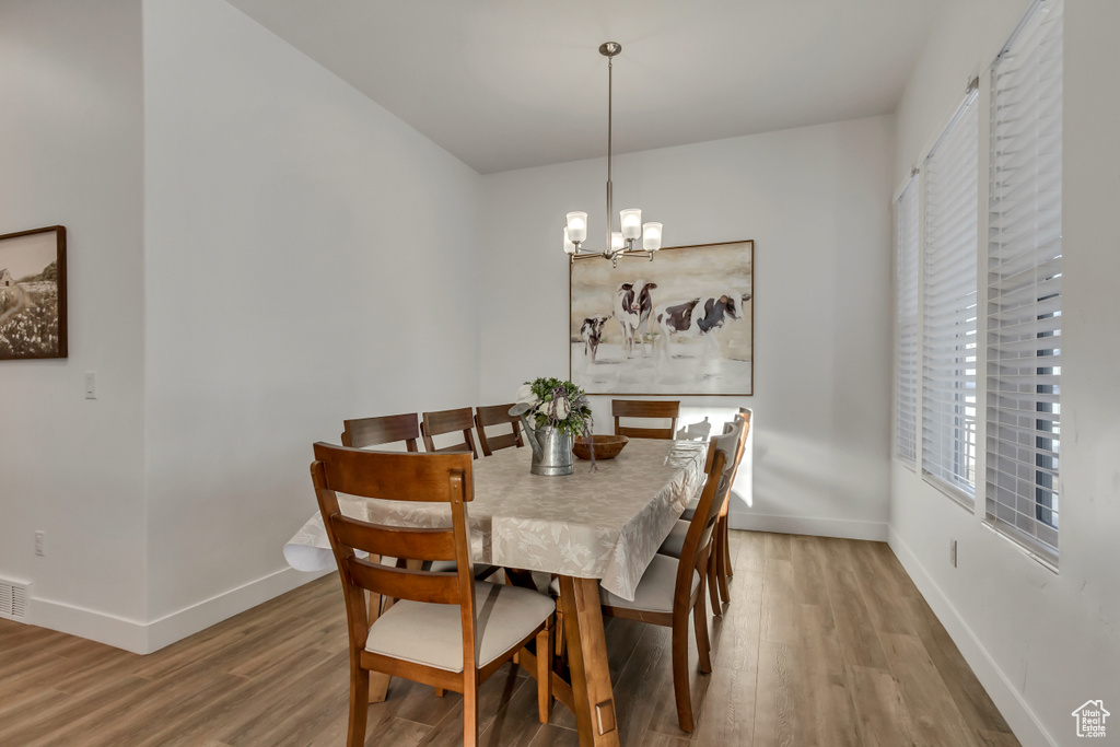 Dining space featuring wood finished floors and a chandelier