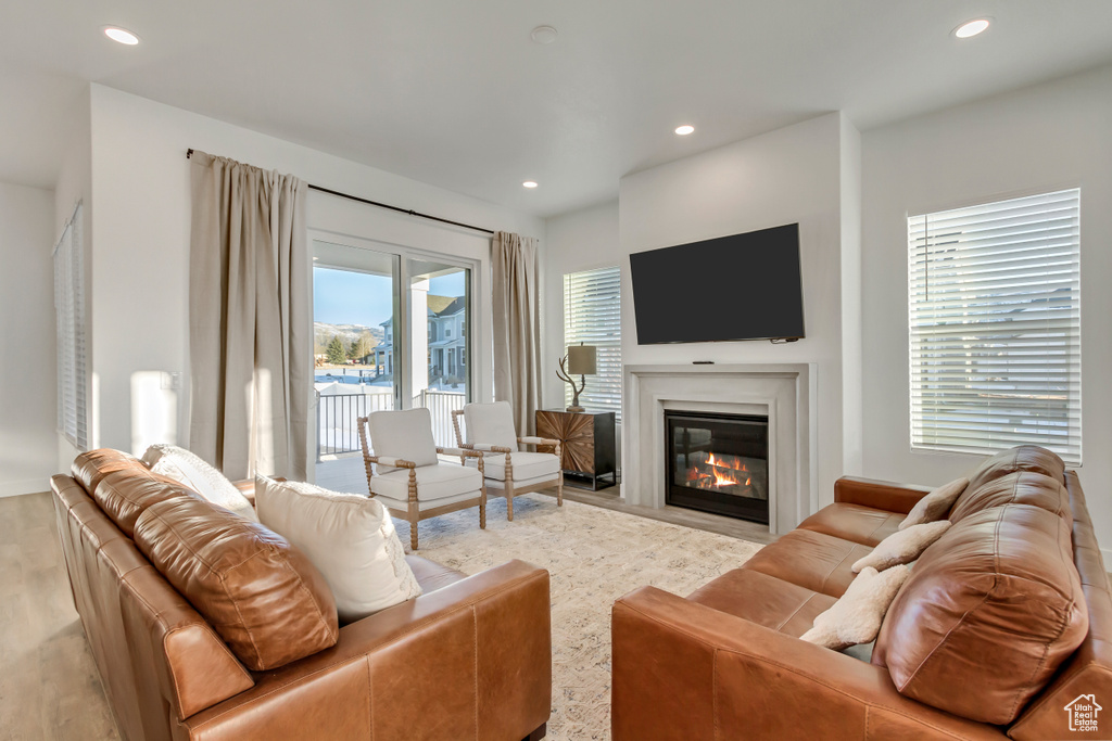 Living room featuring recessed lighting, wood finished floors, and a fireplace with flush hearth