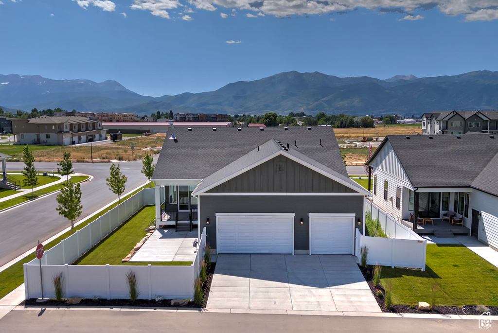 View of front facade with board and batten siding, a mountain view, concrete driveway, and a garage