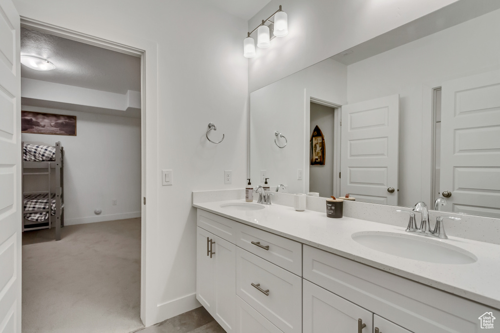 Bathroom featuring double vanity and baseboards