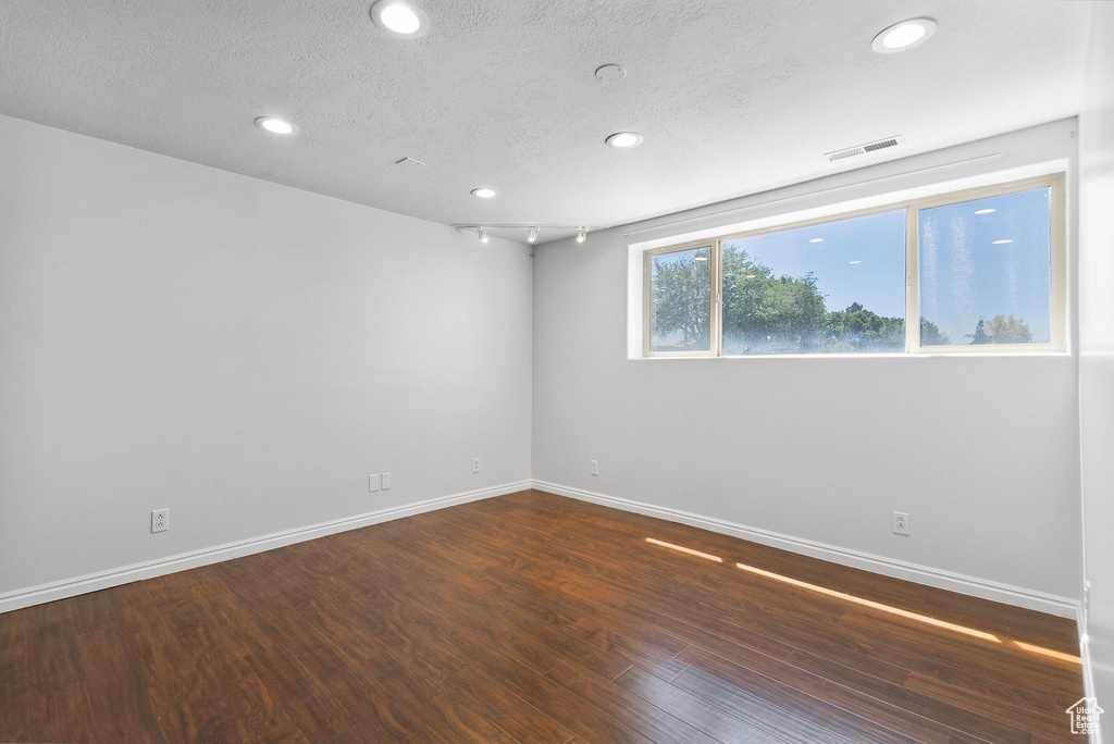 Spare room featuring recessed lighting, dark wood-style flooring, and a textured ceiling