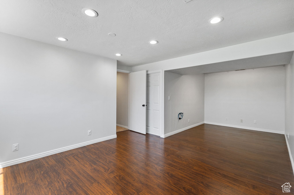 Below grade area featuring recessed lighting, wood finished floors, and a textured ceiling