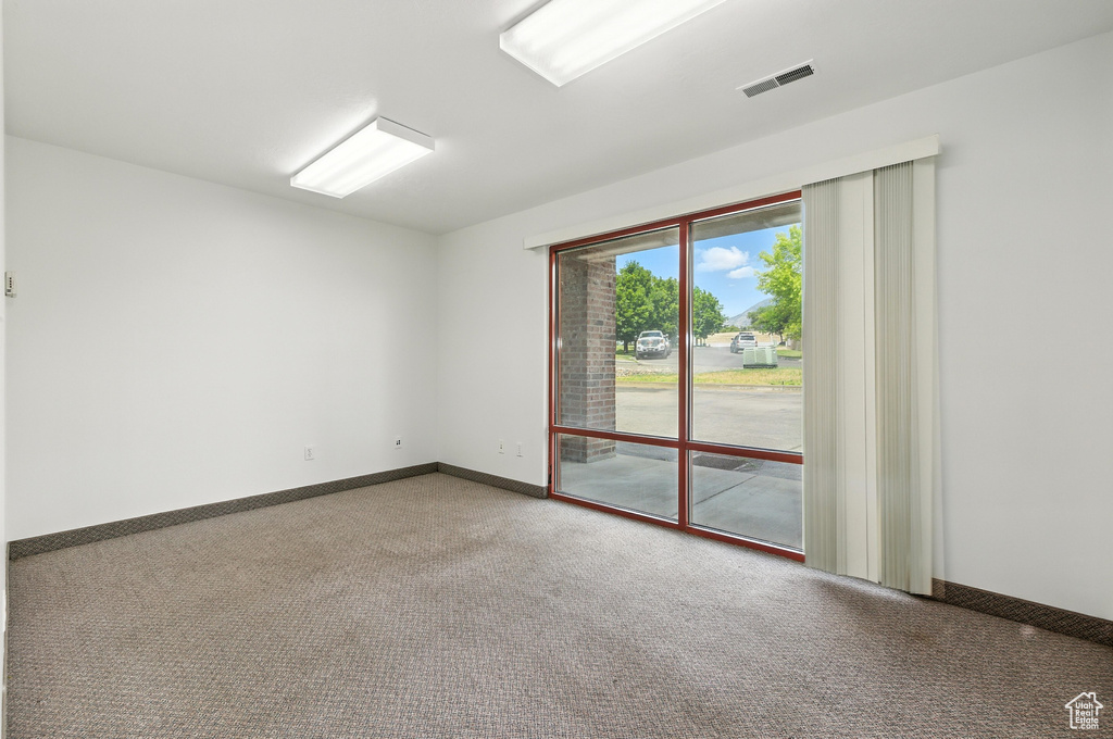 Spare room with carpet and baseboards