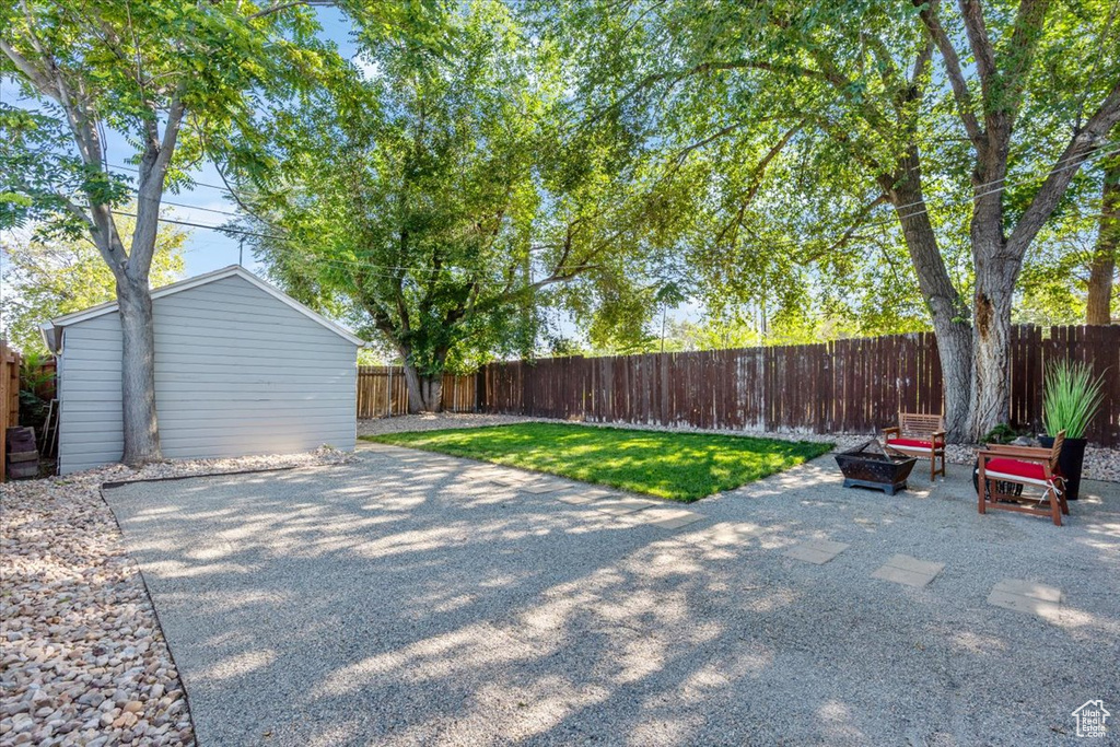 Fenced backyard with a patio area and an outbuilding