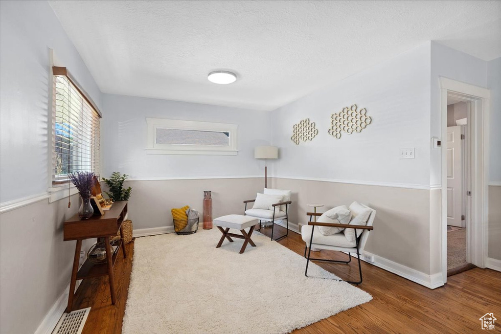 Living area with wood finished floors and a textured ceiling