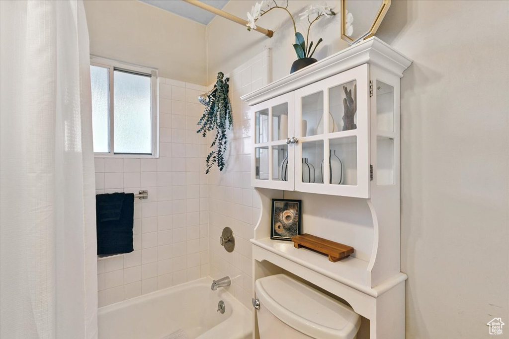 Full bathroom with shower / tub combo with curtain and toilet
