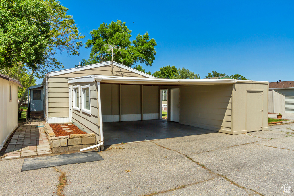 Garage featuring a carport and asphalt driveway