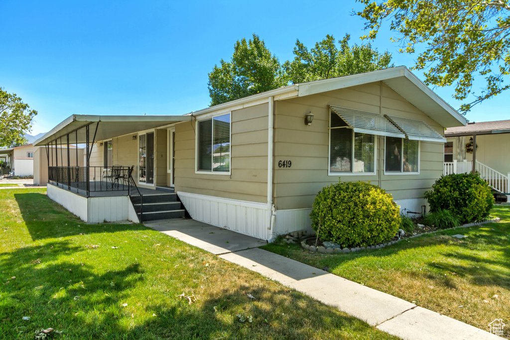 Manufactured / mobile home featuring a porch and a front yard