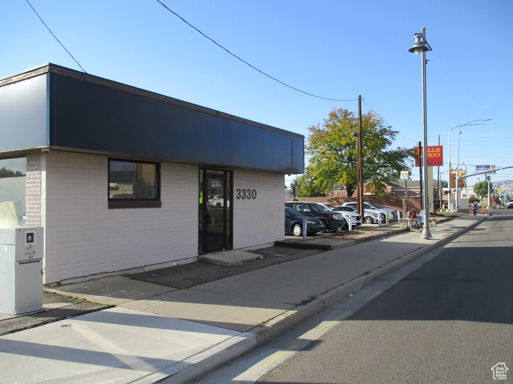 View of asphalt road with sidewalks, street lighting, and curbs