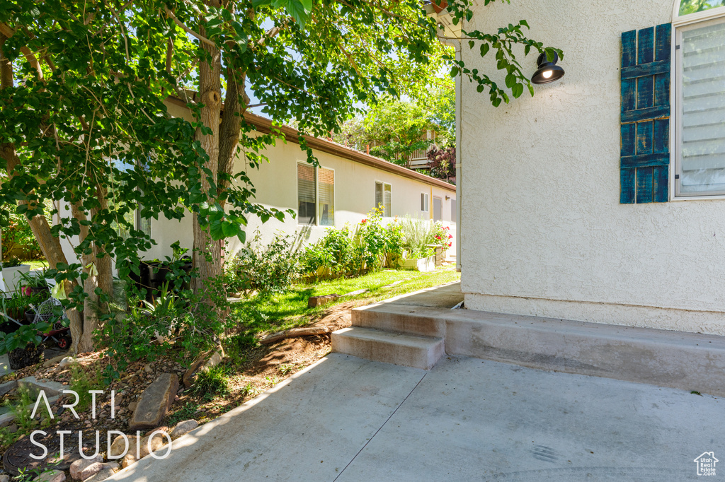View of side of property featuring stucco siding and a patio