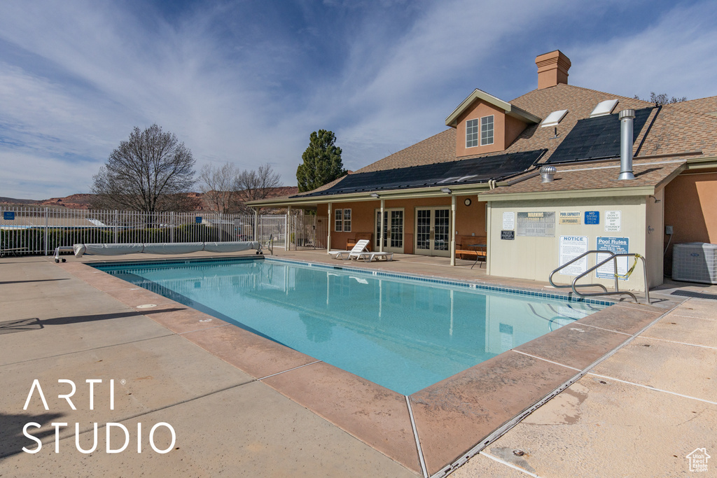 Community pool with french doors and a patio