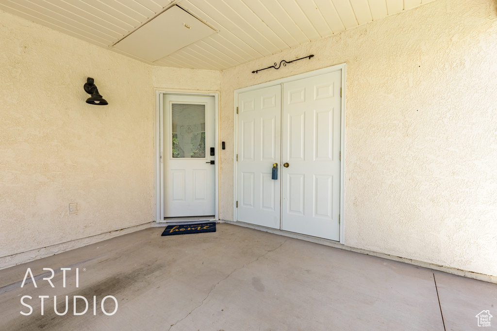 Doorway to property featuring stucco siding