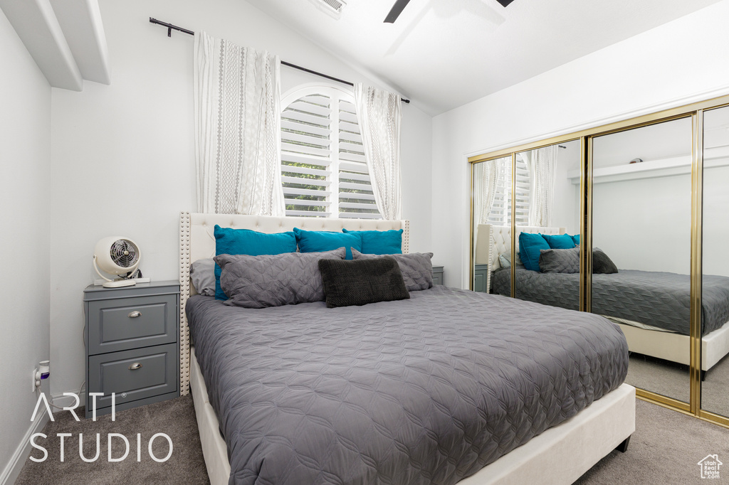 Bedroom with carpet, multiple windows, a closet, and lofted ceiling