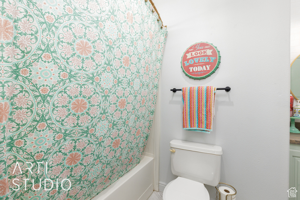 Bathroom featuring shower / bath combo and baseboards