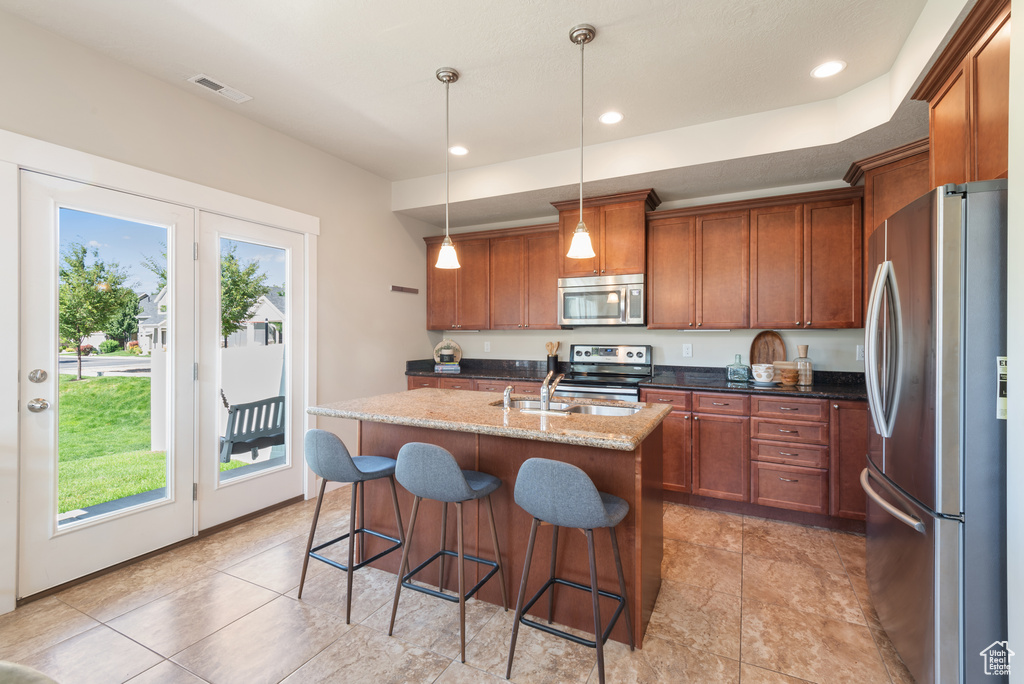 Kitchen featuring stainless steel appliances, plenty of natural light, brown cabinets, and recessed lighting